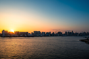 Fototapeta premium Golden sunset over Tokyo Bay and city skyline viewed from a cruise ship in Japan