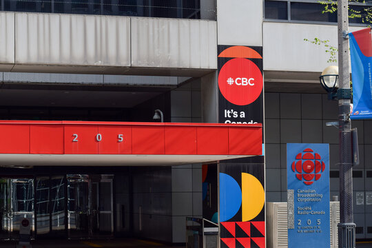 Entrance to the CBC building on Wellington Street in downtown Toronto, showing corporate signage and urban architecture of the Canadian broadcasting headquarters in May 2026