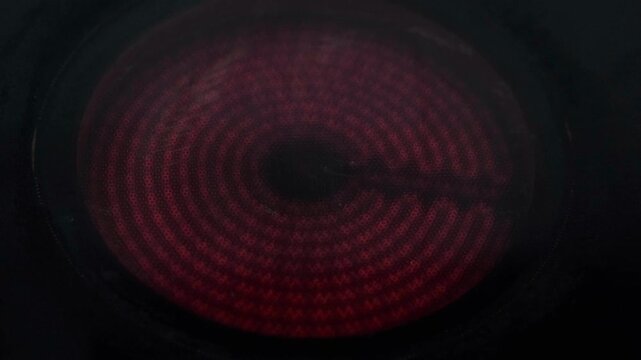 Close Up Macro Shot of Electric Ceramic Hob Stove Burner Heating Up Glowing Bright Red Coils, Modern Infrared Electric Stove Top Active and Turning Red Hot, Household Kitchen Appliances