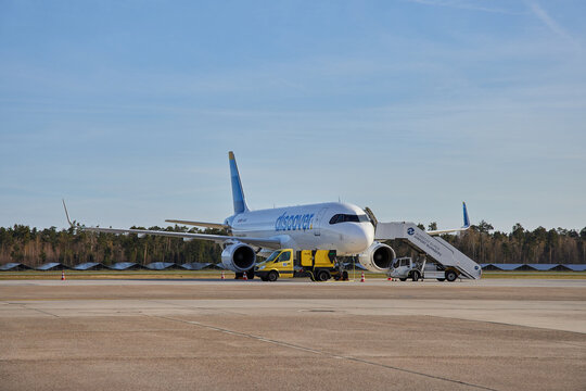 Discover Airlines Airbus A320 airplane parked on tarmac with boarding stairs at Nuremberg Airport.