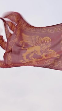 Flag of Veneto Waving in the Wind Against Blue Sky