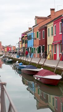 Colorful Murano houses with Boats and Walking Tourists in Venice Italy