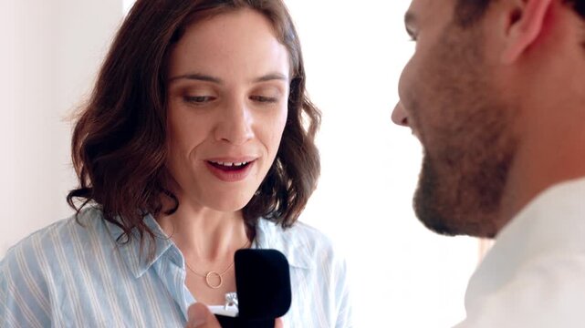 Couple, proposal and excited with ring box in home for commitment, marriage promise and engagement. People, question or romantic gesture in house with love, future together and celebration or yes
