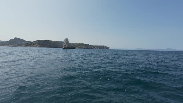 Sailing boat navigating towards pan di zucchero rock in sardinia