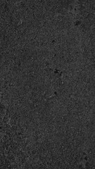 Dark asphalt texture mobile wallpaper with a rough, gritty surface in deep charcoal gray © Rawpixel.com