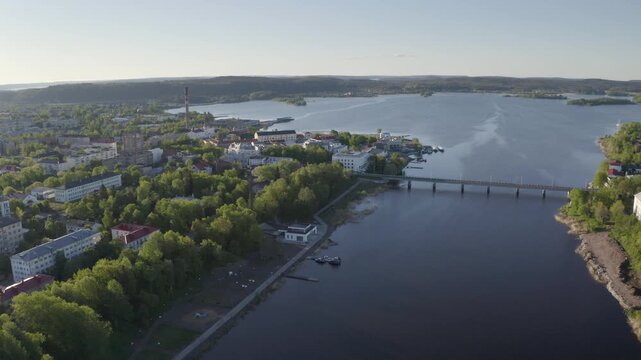 Backward reveal aerial shot of Sortavala town on sunny summer day. Karelia, Russia.