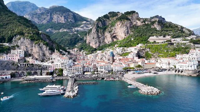 Aerial 4K drone video footage with panorama of Amalfi town on the Amalfi Coast, scenic Mediterranean coastline and historic Italian seaside architecture