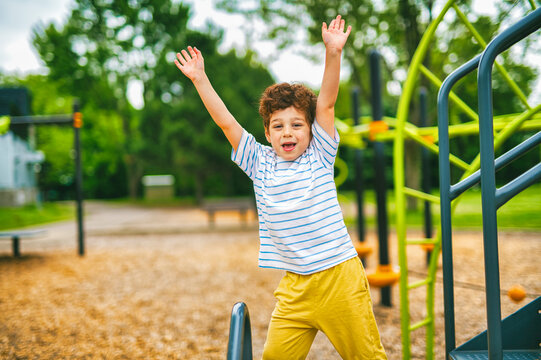 Happy kid on playground on summer season hand up
