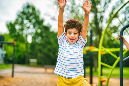 Happy kid on playground on summer season hand up