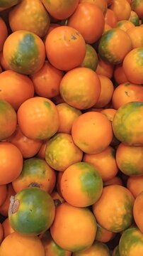 Stacked fresh lulos, whole tropical fruit ready for consumption, natural organic food background. Zoom in on a bunch of naranjilla, a sweet and sour South American fruit
