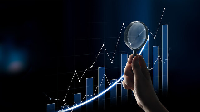 A person examines data trends through a magnifying glass over a digital graph showcasing growth indicators, symbolizing business analysis and research. Scalp