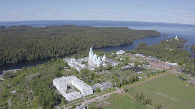 Forward reveal aerial shot of Valaam Monastery and Ladoga lake on sunny summer day. Karelia, Russia.