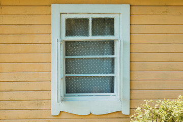 Obraz premium White Window on Yellow Wooden House