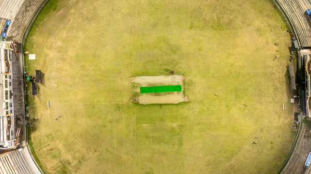 Aerial view of Muzaffarabad Cricket Stadium featuring the green pitch, circular field, and surrounding stands in Muzaffarabad, Azad Kashmir, Pakistan.