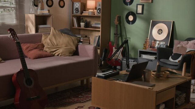 Interior shot of home recording studio equipped with laptop, microphone, electronic instruments for music production