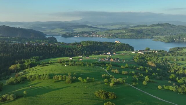 Aerial view of historic Czorsztyn castle on rocky hill by the lake, majestic fortress in Pieniny mountains at sunrise