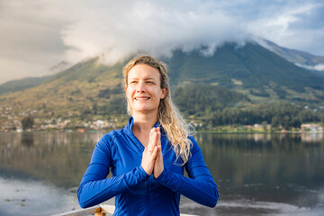 Fototapeta premium Woman smiling, finding balance and mindfulness during a yoga practice near a calm lake