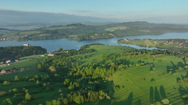 Aerial view of historic Czorsztyn castle on rocky hill by the lake, majestic fortress in Pieniny mountains at sunrise