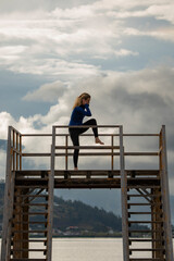 Fototapeta premium Woman performing a yoga pose on a wooden pier overlooking yahuarcocha lake