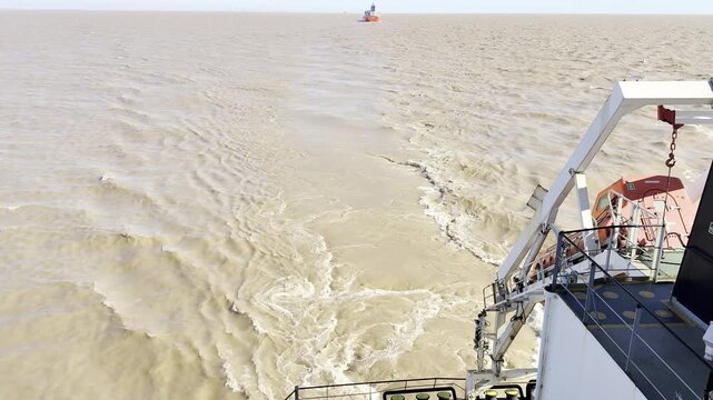 ships proceeding in a narrow canal. river water full of clay, very dirty, have specific color