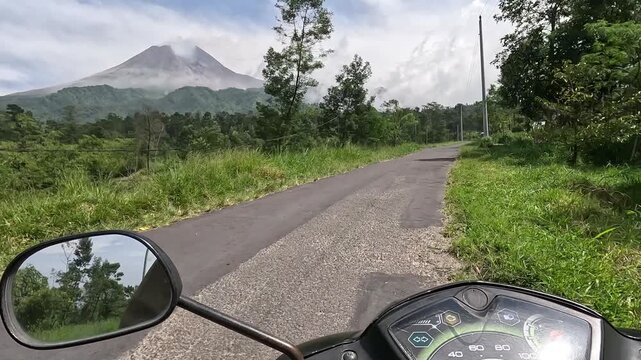 Driving a motorbike on the road to an active volcano, first-person view