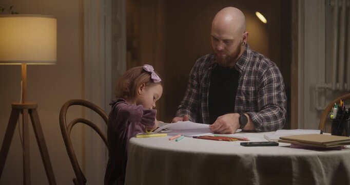 A father and daughter joyfully share creative moments while drawing at their dining table in a warm, inviting home