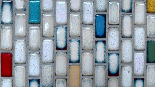 Approaching a tiled surface of diverse rectangular pieces. Mosaic backdrop close up.