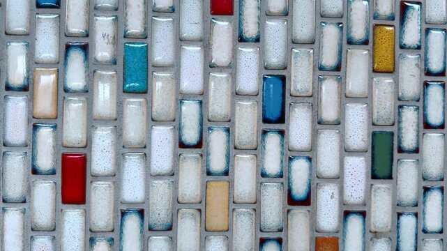Wall of tiled pieces of diverse colors. Decor concept. Ceramic mosaics close up.
