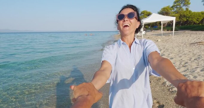 Joyful Woman Spinning on Beach at Sunset with Partner