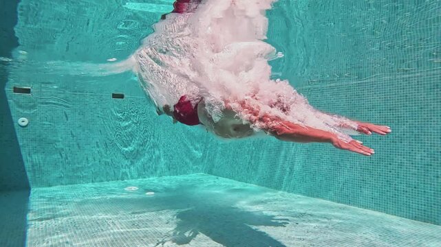Professional Man Jumping Underwater into Swimming Pool
