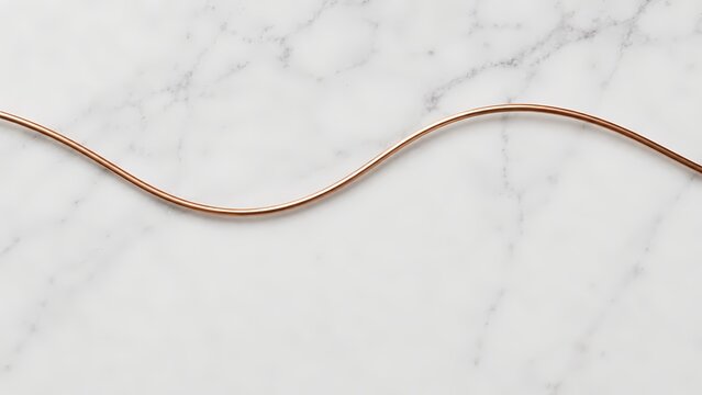 Copper wire on a white marble surface in a wavy pattern