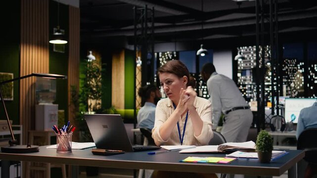 Businesswoman working on project in modern startup office using laptop, happy employee at computer desk analyzing data statistics during business audit late at night. Corporate productivity.