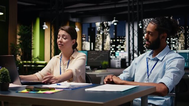 Man with reduced mobility in wheelchair and woman colleague collaborating on company project, emphasizing dream team. Together they review data and conduct research, corporate planning.