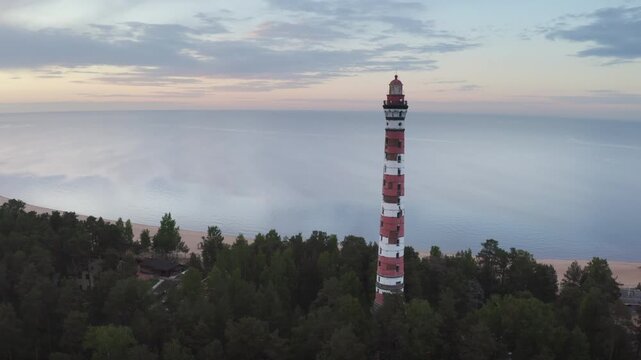 Panoramic aerial shot of Osinovetsky lighthouse and Ladoga lake on summer sunset. Ladozhskoye Osero village, Leningrad Oblast, Russia.