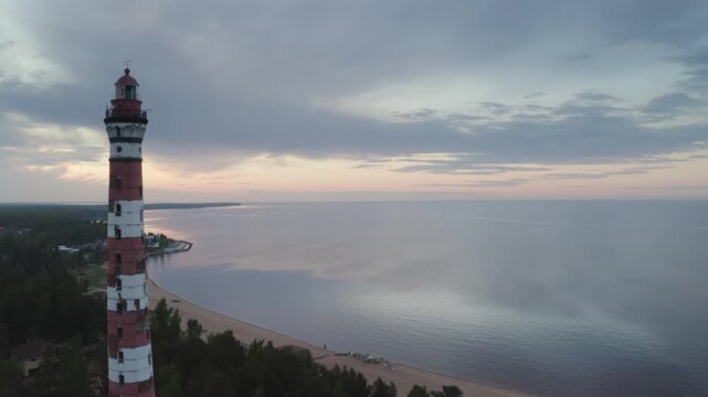 Aerial footage of Osinovetsky lighthouse and Ladoga lake on summer sunset. Ladozhskoye Osero village, Leningrad Oblast, Russia.