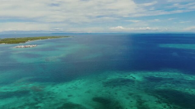 Rotating drone view of Mucura Island with Tintipan, Santa Cruz del Islote and colorful sea