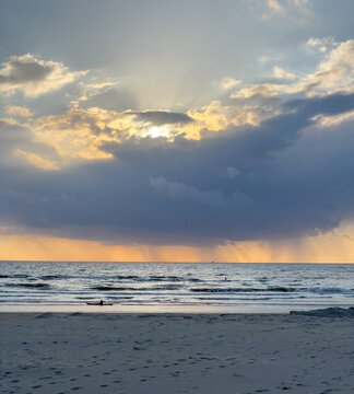 View of Strand Wijk aan Zee with sunbeams breaking through dramatic clouds over the North Sea Wijk aan Zee, North Holland, Netherlands.