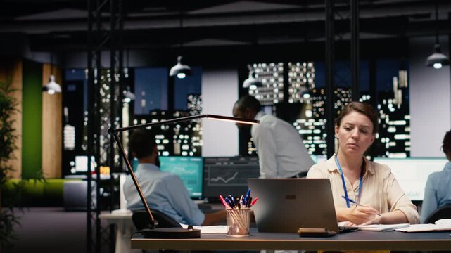 Woman accountant writing down information and working overtime to finish paperwork task before deadline. Bookkeeper working for company and documenting business intel, data insights.