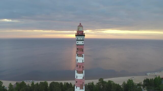 Orbital aerial shot of Osinovetsky lighthouse and Ladoga lake on summer sunrise. Ladozhskoye Osero village, Leningrad Oblast, Russia.