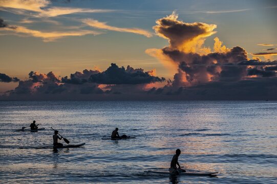 Surfers at sunset in Guam, US Territory, Central Pacific