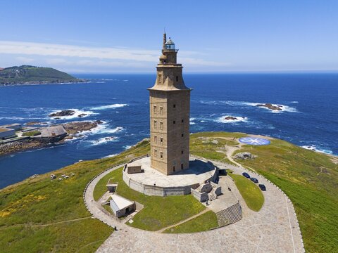 A striking lighthouse structure standing on a picturesque coastline surrounded by the deep blue sea and green land, aerial view, Torre de H&eacute;rcules, Torre de Hercules, Roman Tower of Hercules, A Coru&ntilde;a, A Coruna, La Coru&ntilde;a, La Coruna, Galicia, Spain