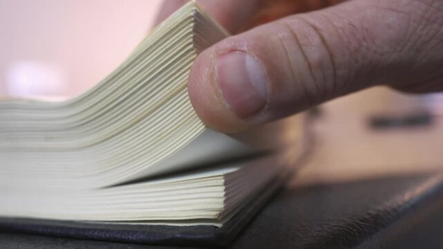 Close Up Hand Flipping Old Book Pages