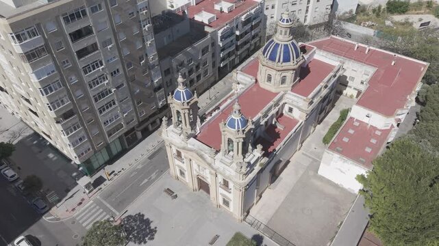 Aerial view of San Jose Church in Cadiz, Spain. Cinematic drone shot of the historic Neoclassical parish and surrounding city streets on a sunny day.