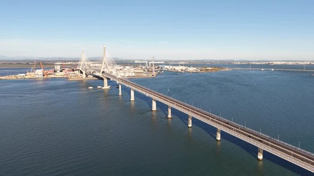 Aerial view of the Constitution of 1812 Bridge in Cadiz, Spain. Cinematic drone shot of the modern landmark cable-stayed bridge over the bay on a sunny day