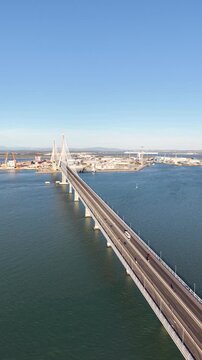 Aerial view of the Constitution of 1812 Bridge in Cadiz, Spain. Cinematic drone shot of the modern landmark cable-stayed bridge over the bay on a sunny day