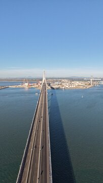 Aerial view of the Constitution of 1812 Bridge in Cadiz, Spain. Cinematic drone shot of the modern landmark cable-stayed bridge over the bay on a sunny day