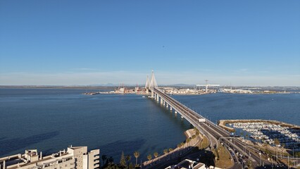 Aerial view of the Constitution of 1812 Bridge in Cadiz, Spain. Cinematic drone shot of the modern landmark cable-stayed bridge over the bay on a sunny day