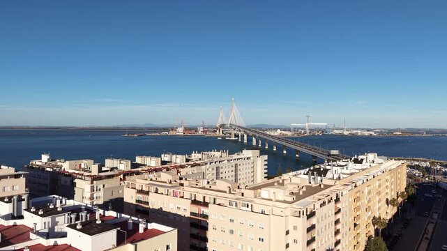 Aerial view of the Constitution of 1812 Bridge in Cadiz, Spain. Cinematic drone shot of the modern landmark cable-stayed bridge over the bay on a sunny day