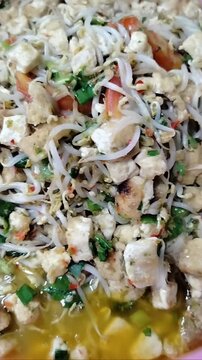 Stir-fried tofu and bean sprouts in a wok. Simple Indonesian home cooking (Tumis Tahu Tauge), healthy vegetarian dish, savory Asian cuisine, Close-up food videography.