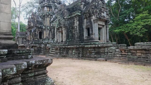 The ancient Thommanon Temple, Siem Reap, Cambodia. , stand weathered and overgrown, showcasing intricate stone carvings and moss-covered walls.